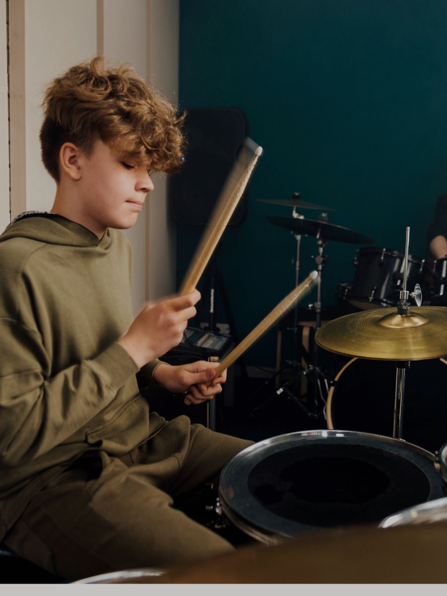 Pessoa tocando bateria em aula na Bee Music