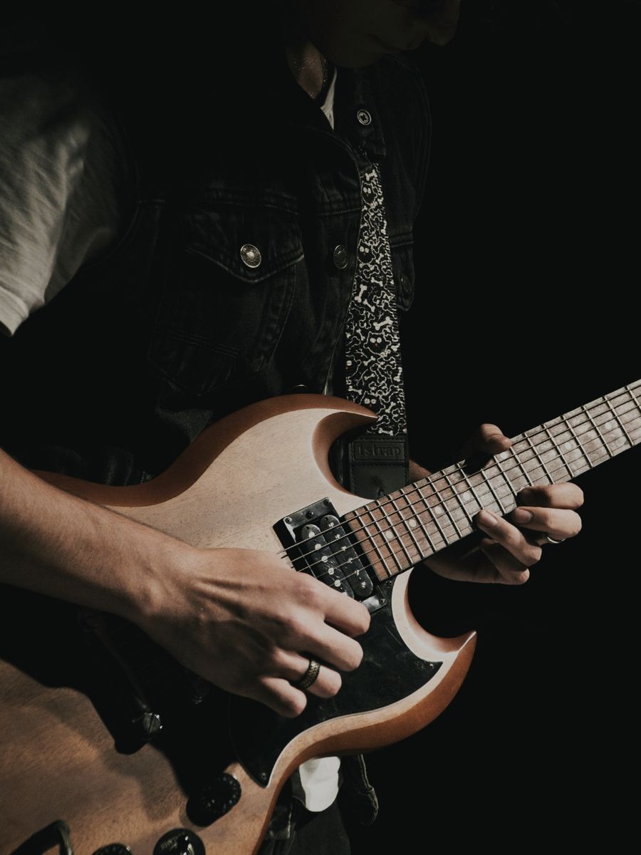 Pessoa tocando guitarra elétrica em aula na Bee Music
